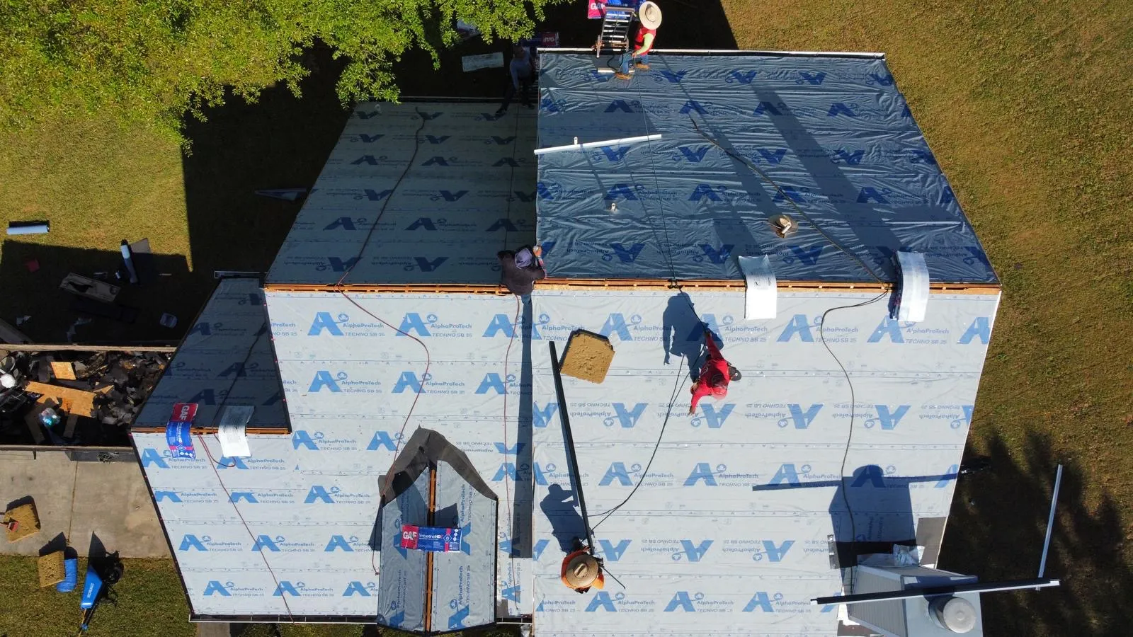 Roofing crew installing premium blue underlayment on an Atlanta home